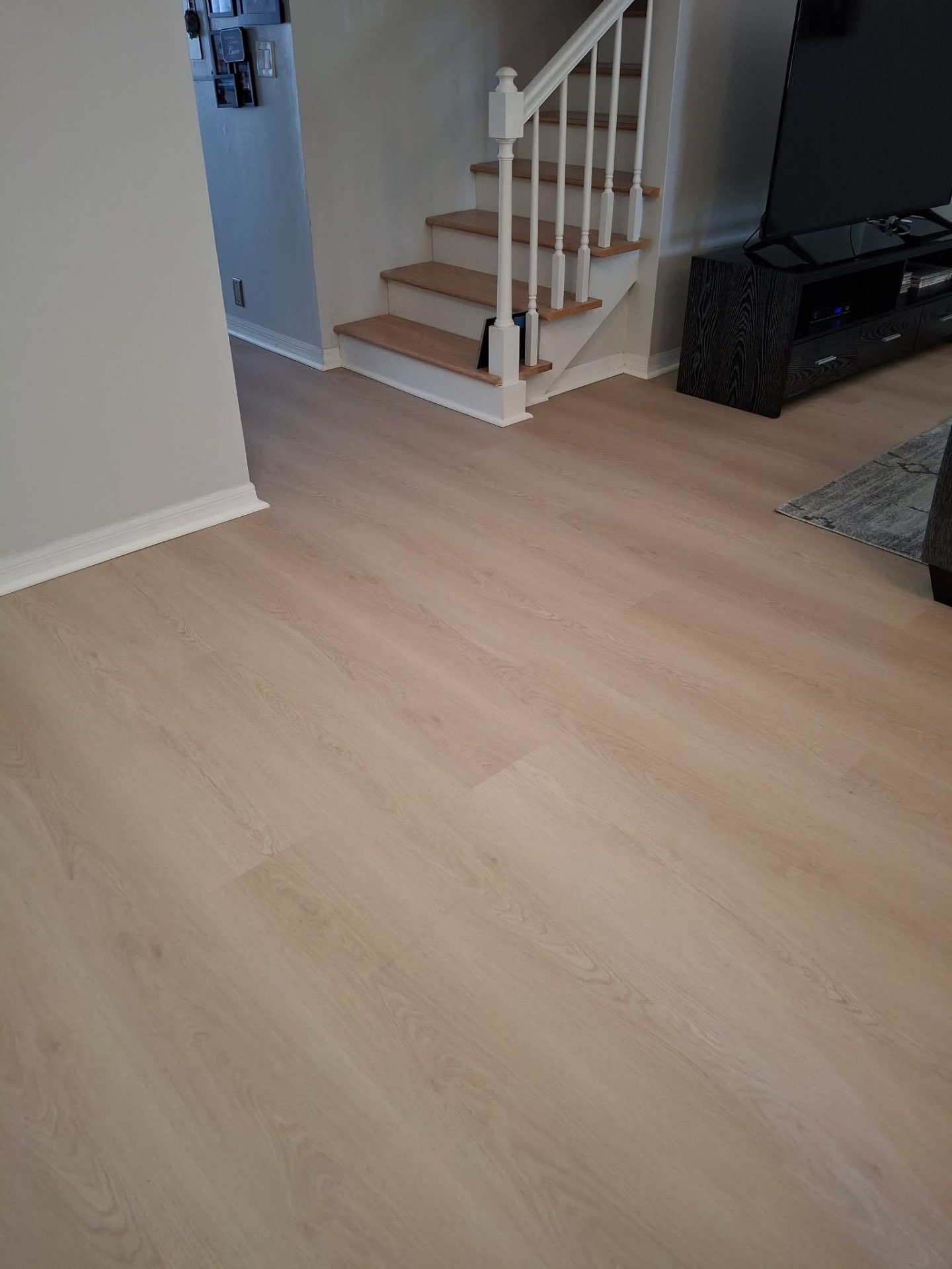 Finished light-toned flooring near a staircase